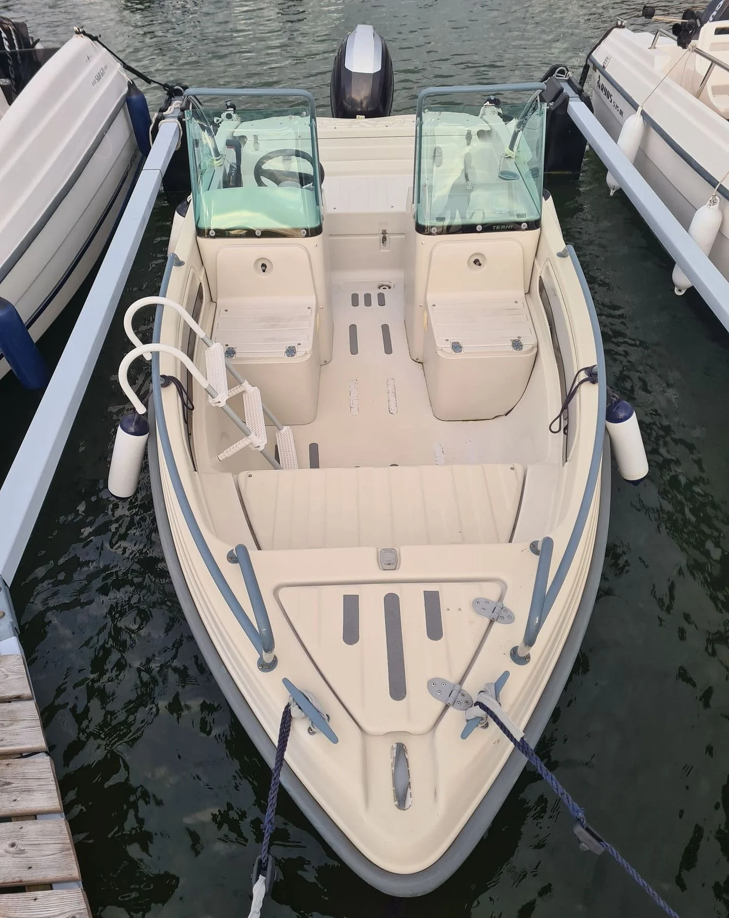 Center console recreational fishing boat moored at dock in calm Florida waters.