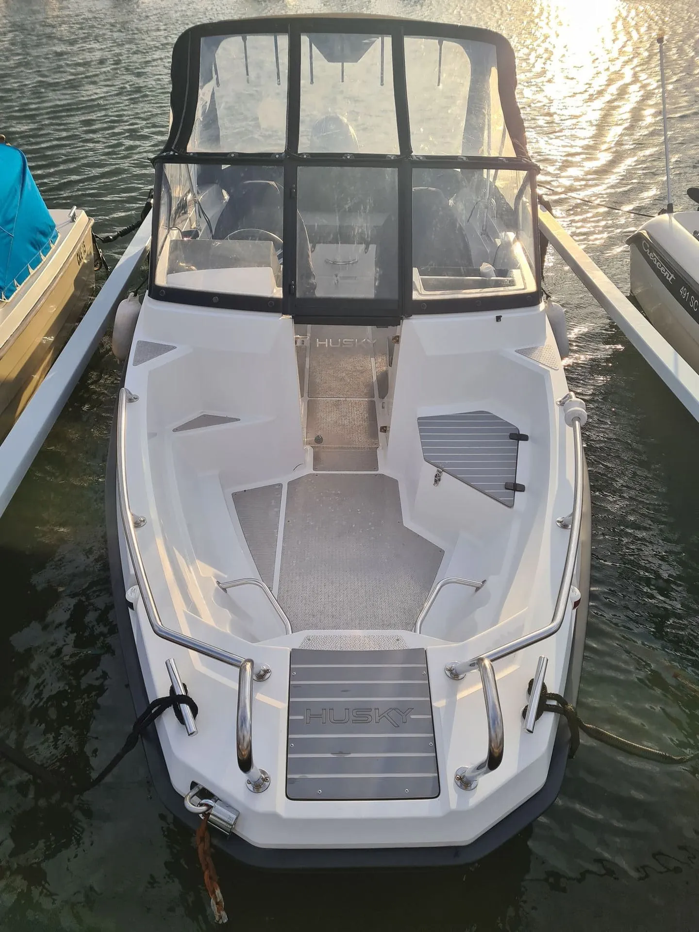 White recreational fishing boat moored in calm water, viewed from above at a St. Petersburg marina.