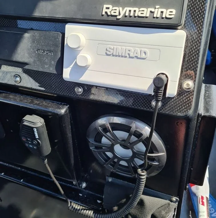 Marine electronics control panel with GPS and fish finder mounted on boat console.