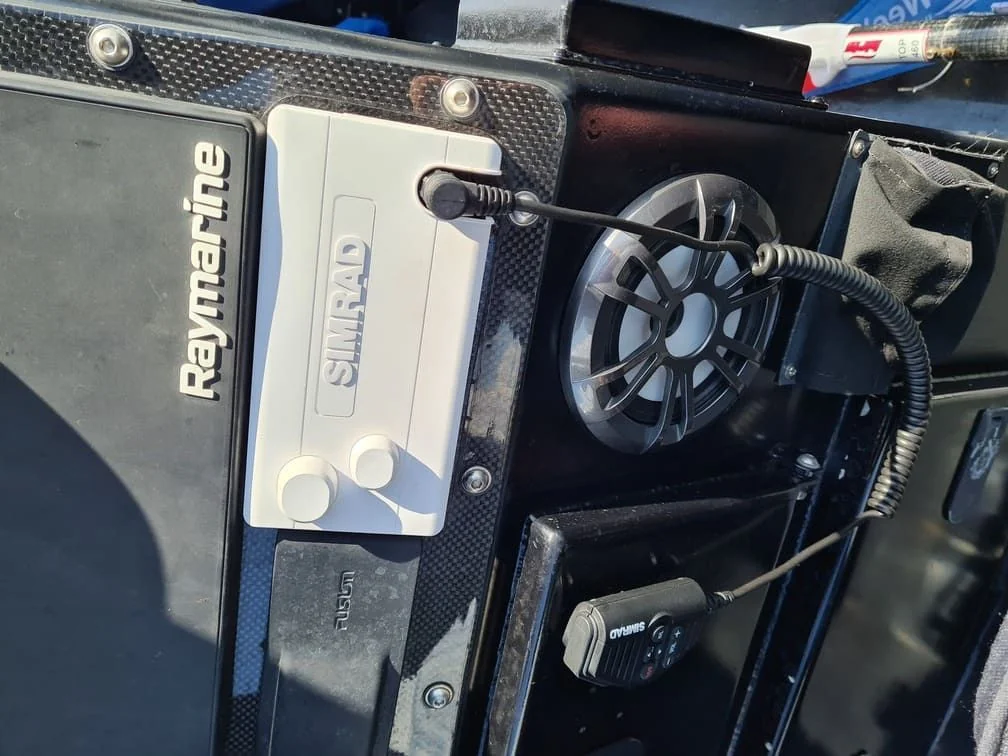 Marine electronics and fishfinder mounted on boat console with wiring and cables visible.