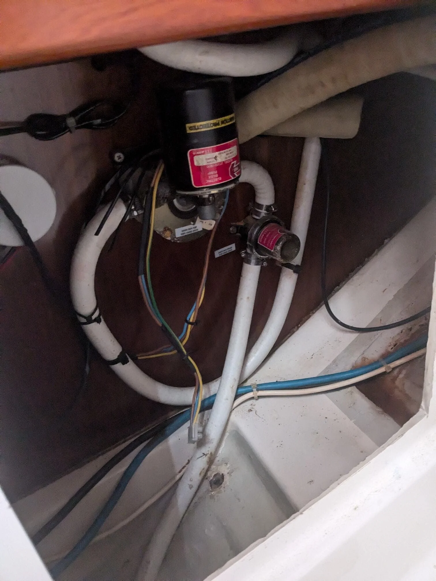 Marine electrical system with dual battery switches and color-coded wiring inside boat compartment.