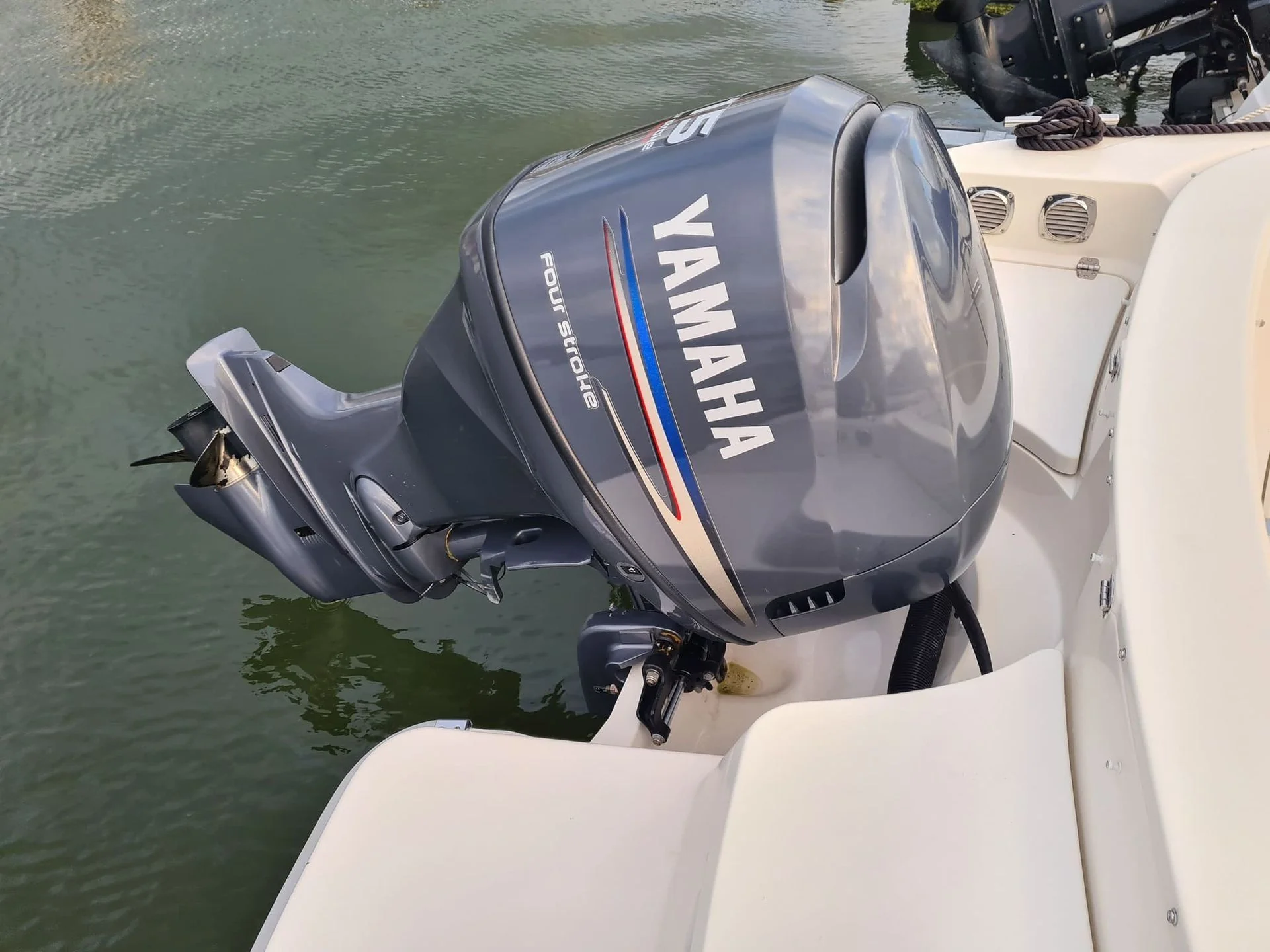 Outboard motor mounted on boat transom in St. Petersburg waterway, ready for service.