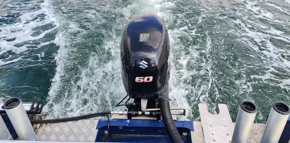 60-horsepower outboard motor mounted on boat transom, active in Gulf waters near St. Petersburg.