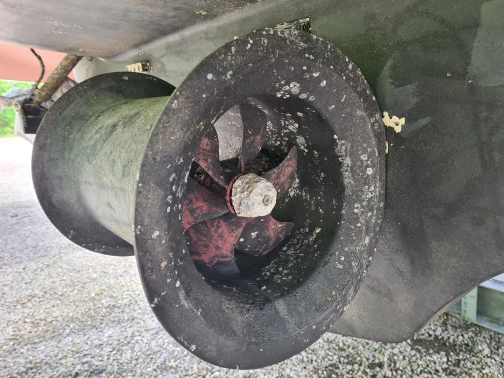Corroded outboard motor propeller with marine growth and oxidation damage visible.